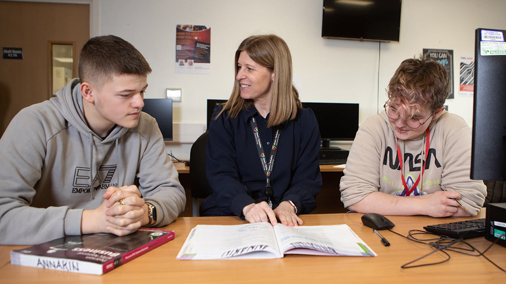 Two students in the classroom with a tutor