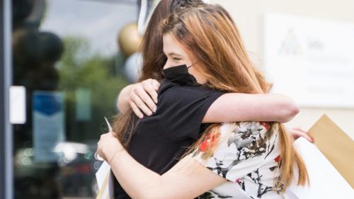 Students hugging with their results 