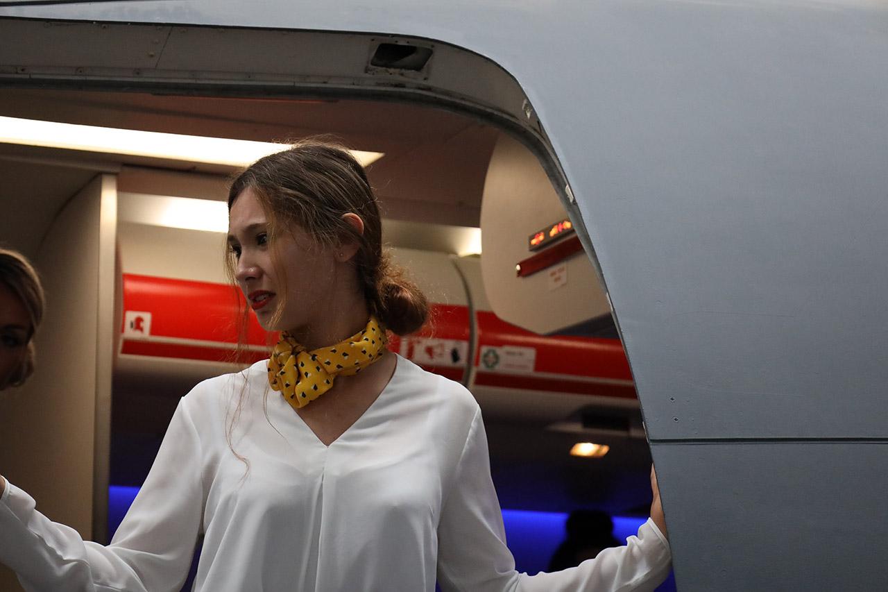 Travel and tourism students learning to close an airplane door.