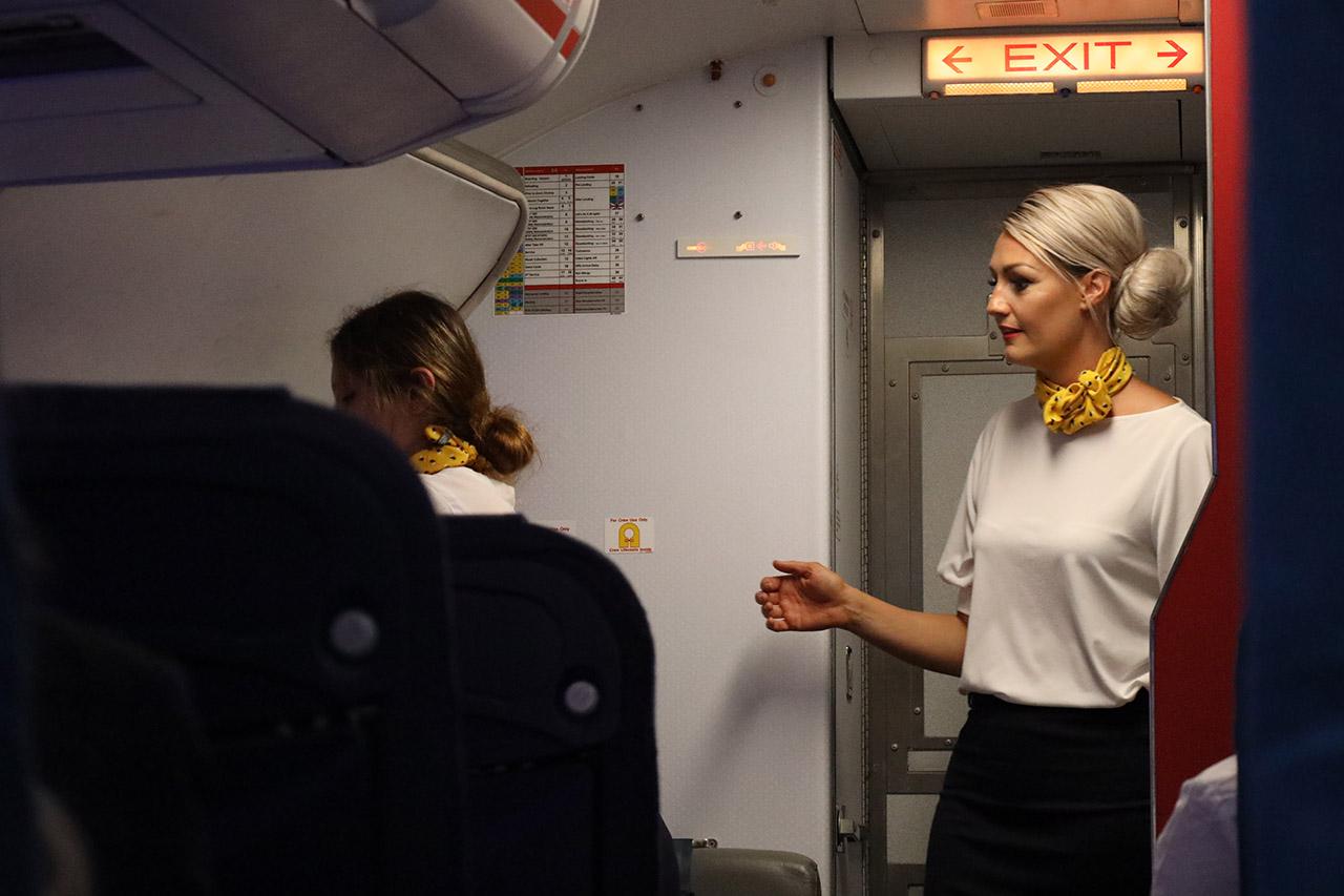 Travel and tourism students learning to close an airplane door.