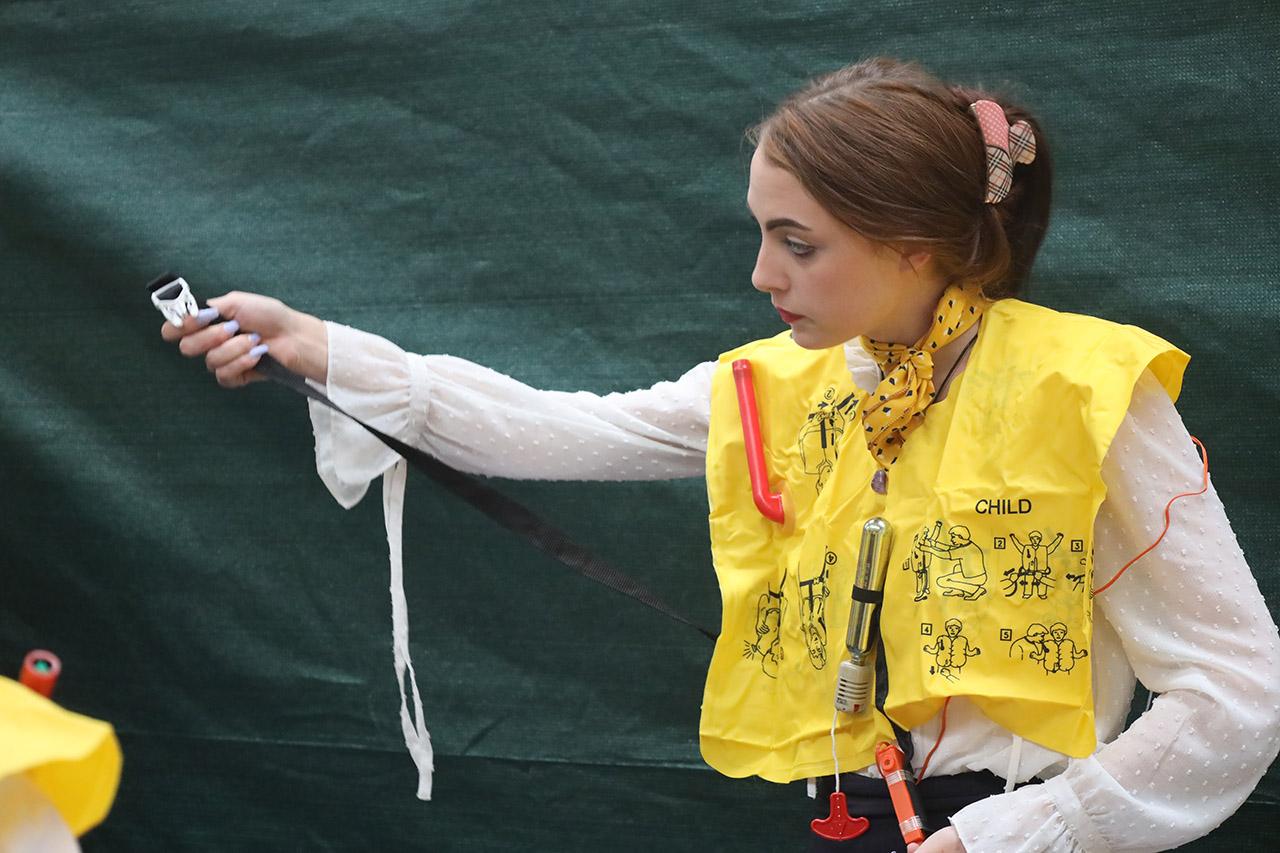 Travel and tourism students learning to close an airplane door.